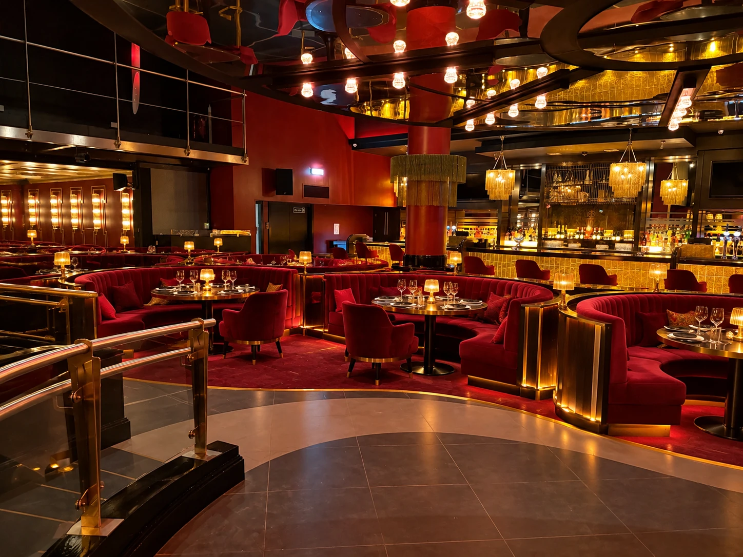 The club's main room: red velvet booths, brass lamps and a gold-lit bar