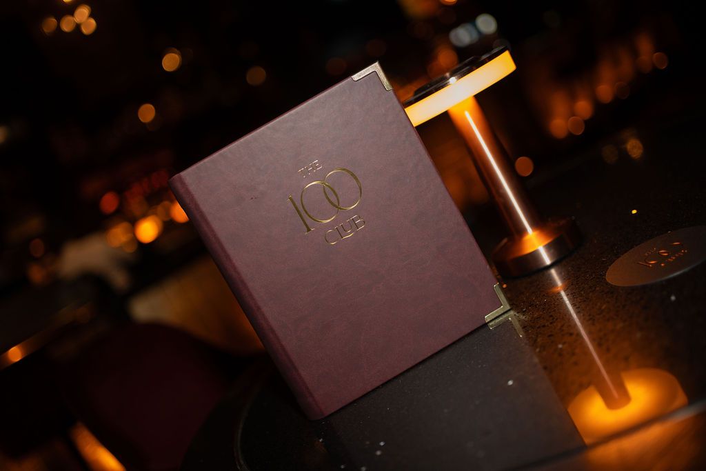 The 100 Club menu on a candlelit table